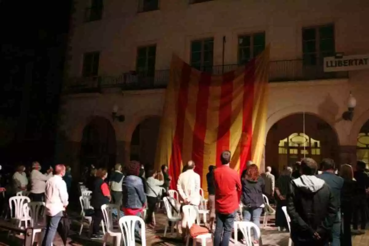 Persones mirant la senyera a la plaça del Blat de Valls