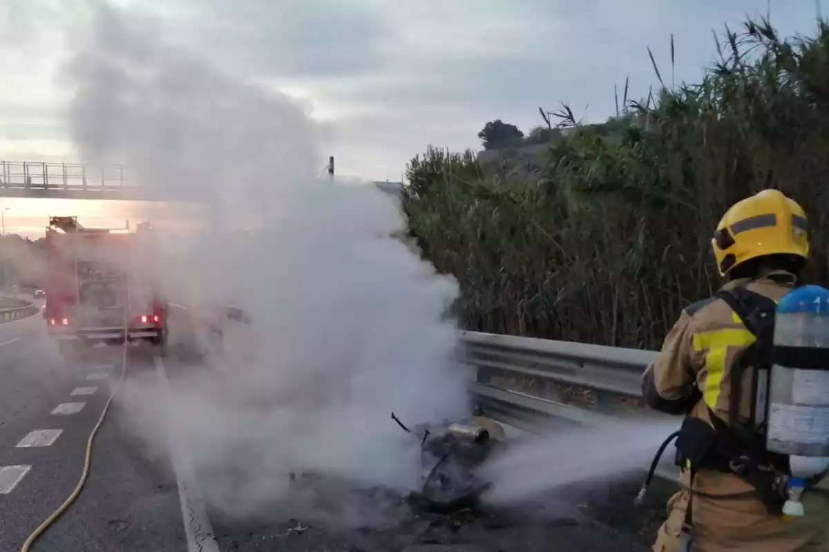 Els Bombers extingint un incendi en una moto a l'A-7