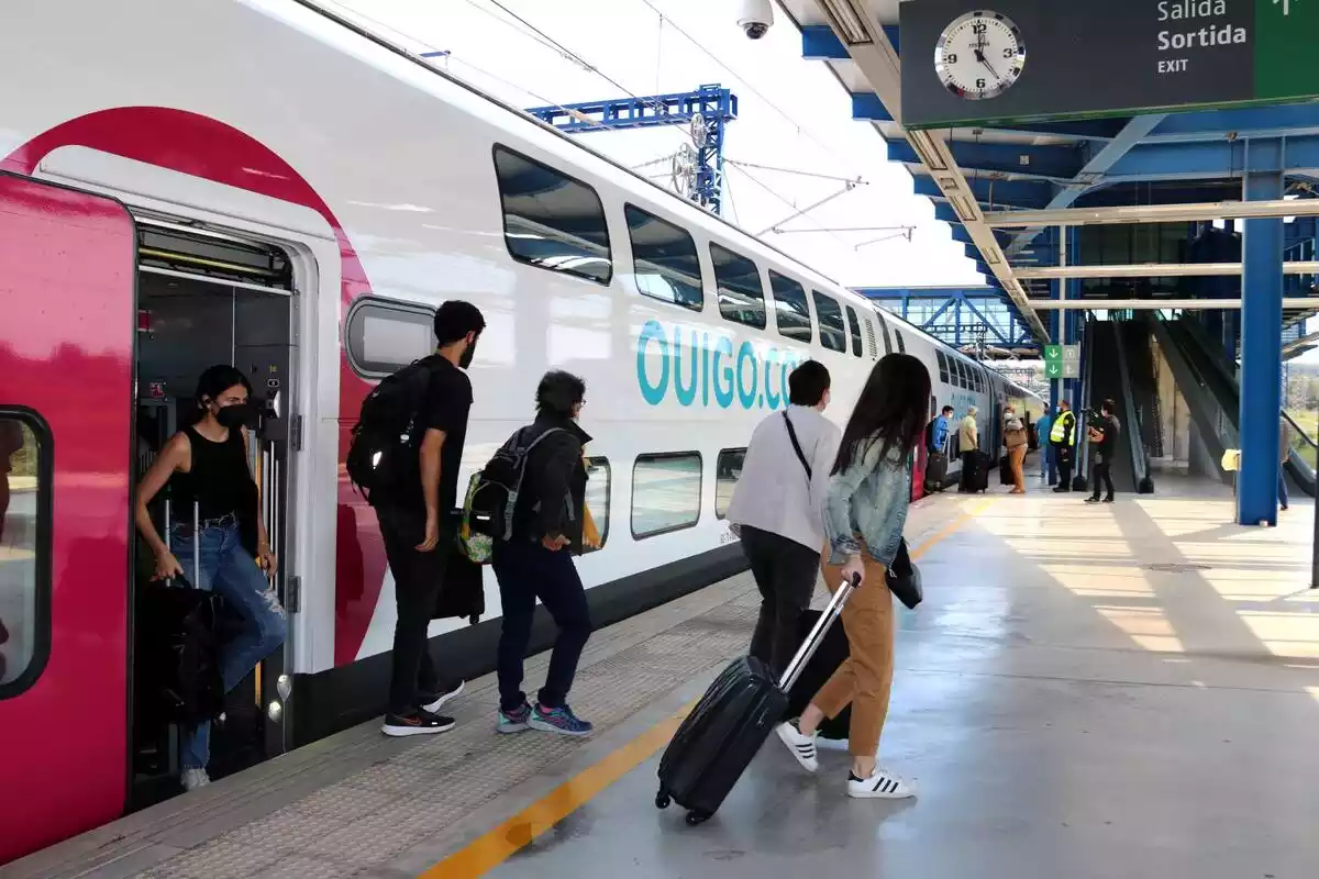 Pla general de diversos passatgers sortint del comboi d'un tren d’Ouigo a l'estació del Camp de Tarragona