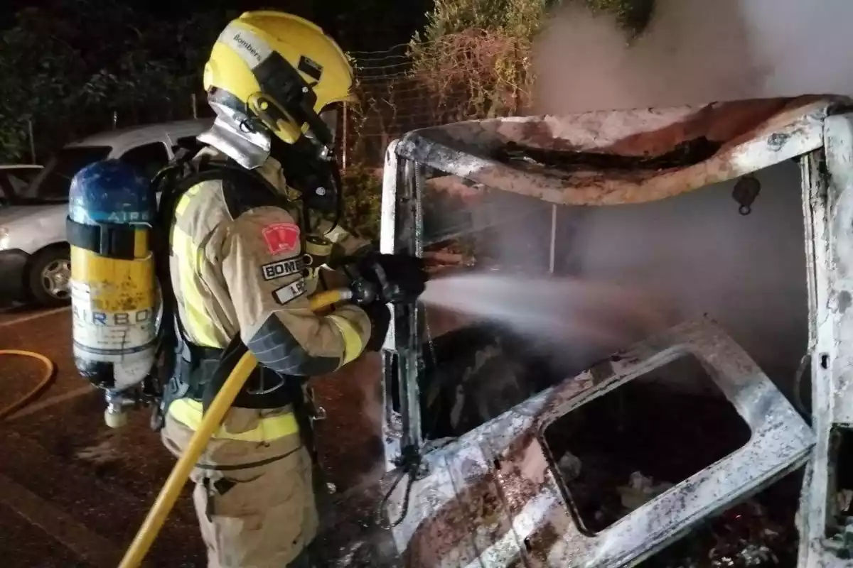 Un bomber apagant un foc en un cotxe a Reus