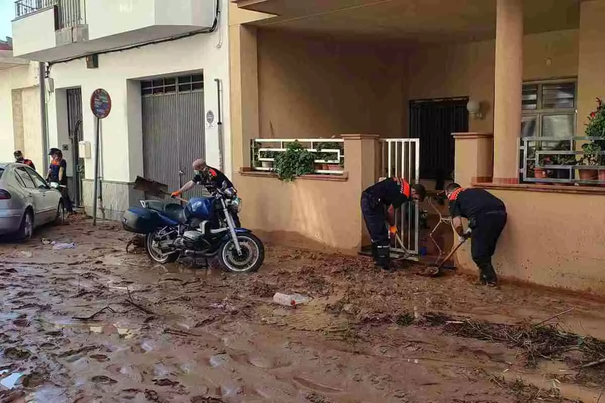 Voluntaris de Protecció Civil netegen l'entrada d'una casa a Alcanar