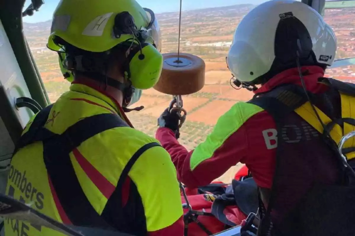 Bombers en un helicòpter rescatant una persona accidentada