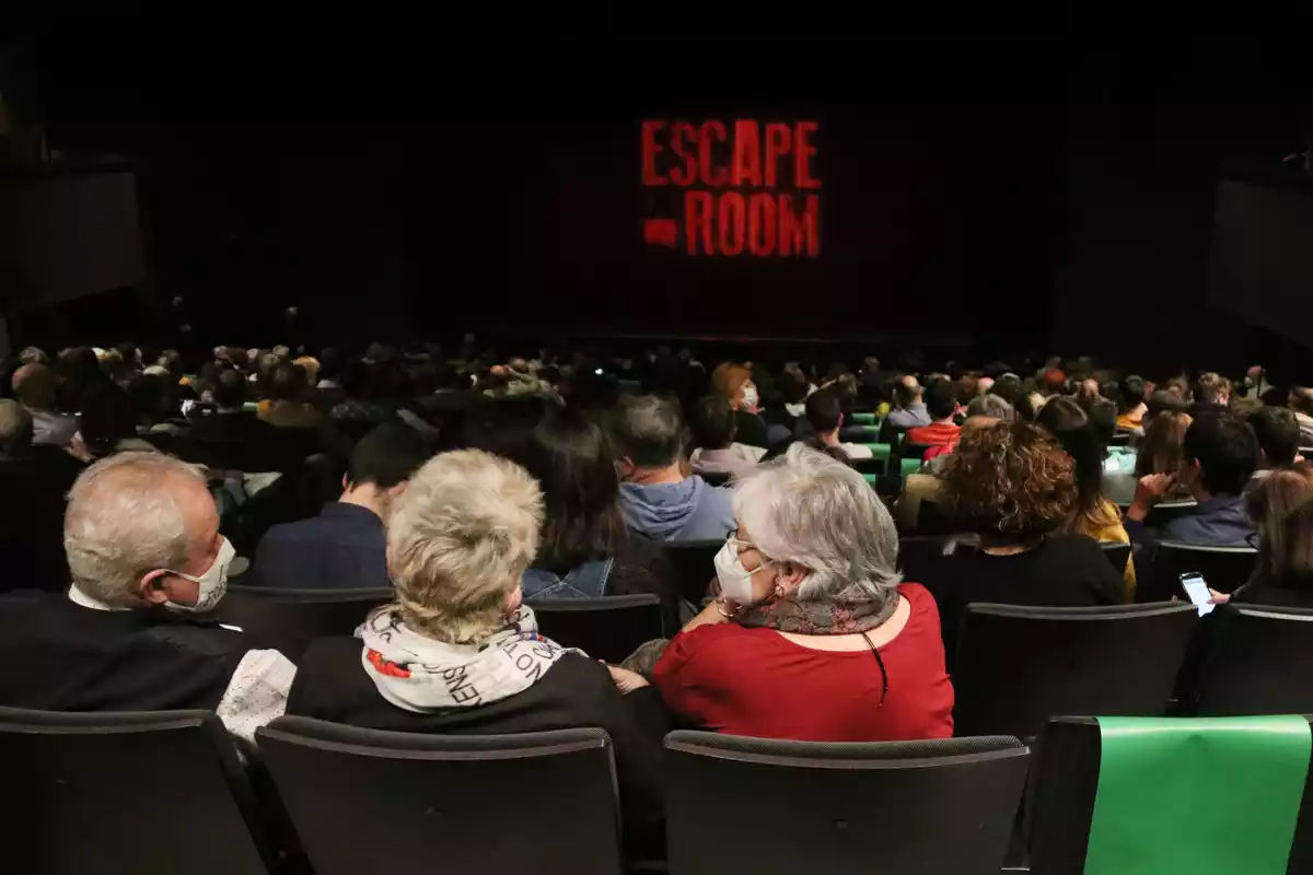 Espectadors amb mascareta esperen l'inici de la primera funció al Teatre Goya després de l'aixecament del tancament cultural