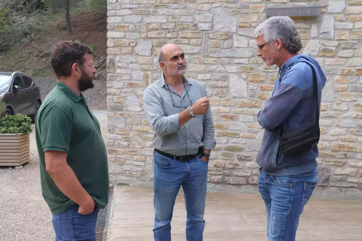 Joan Vidal, Sal·lustià Àlvarez i Sergi Saladié, conversant a l'entrada del celler La Conreria d'Escaladei