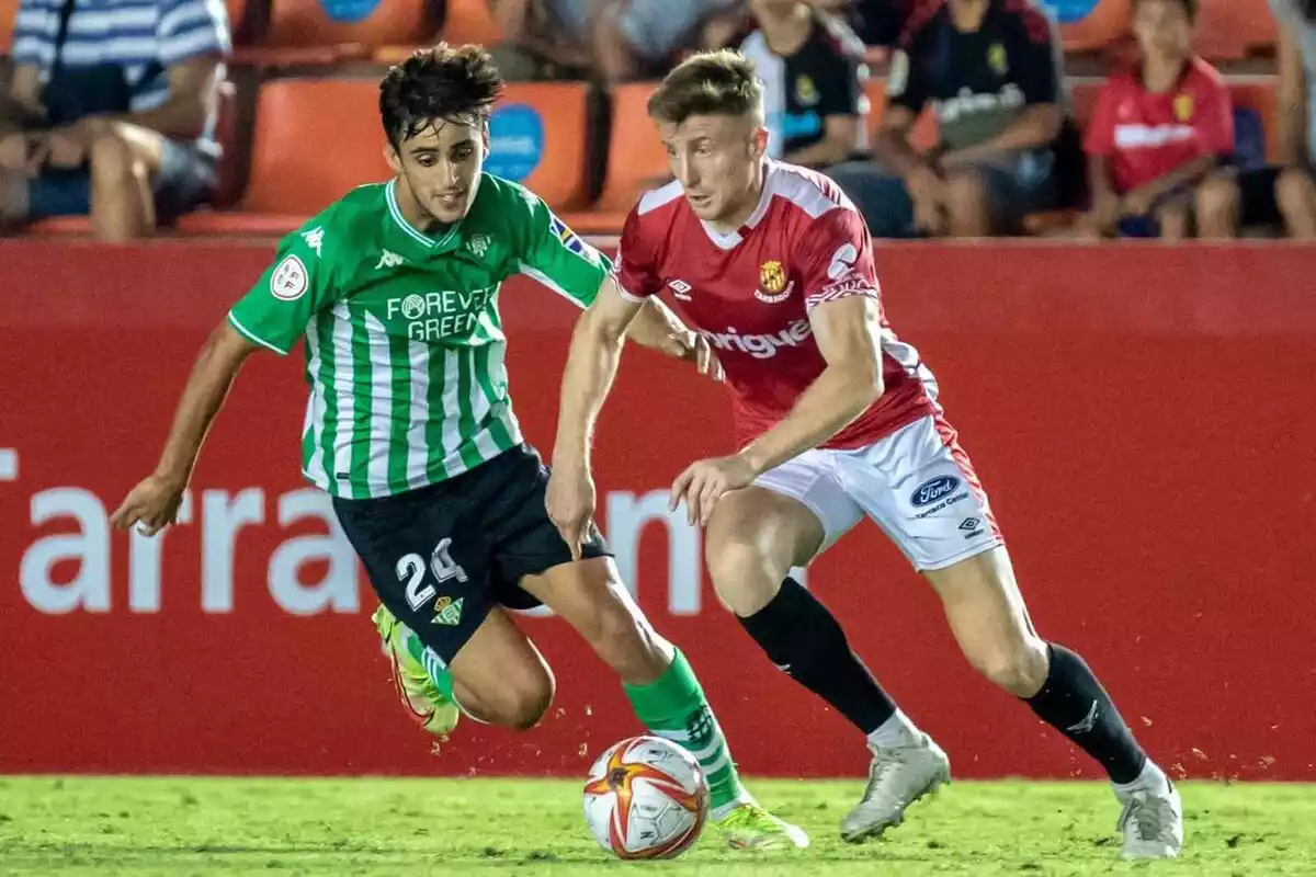 Dos jugadors de futbol en un partit