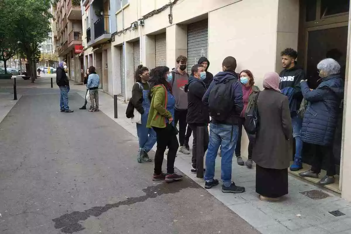 Un grup de persones concentrat a la porta del número 41 del carrer de Sant Magí de Reus