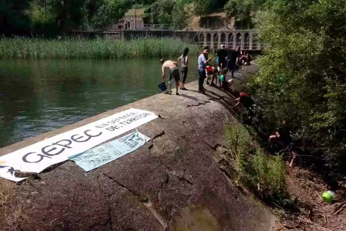 Un grup d'activistes a l'assut del riu Siurana amb una pancarta de Gepec i una de la Paltaforma pel Riu Siurana