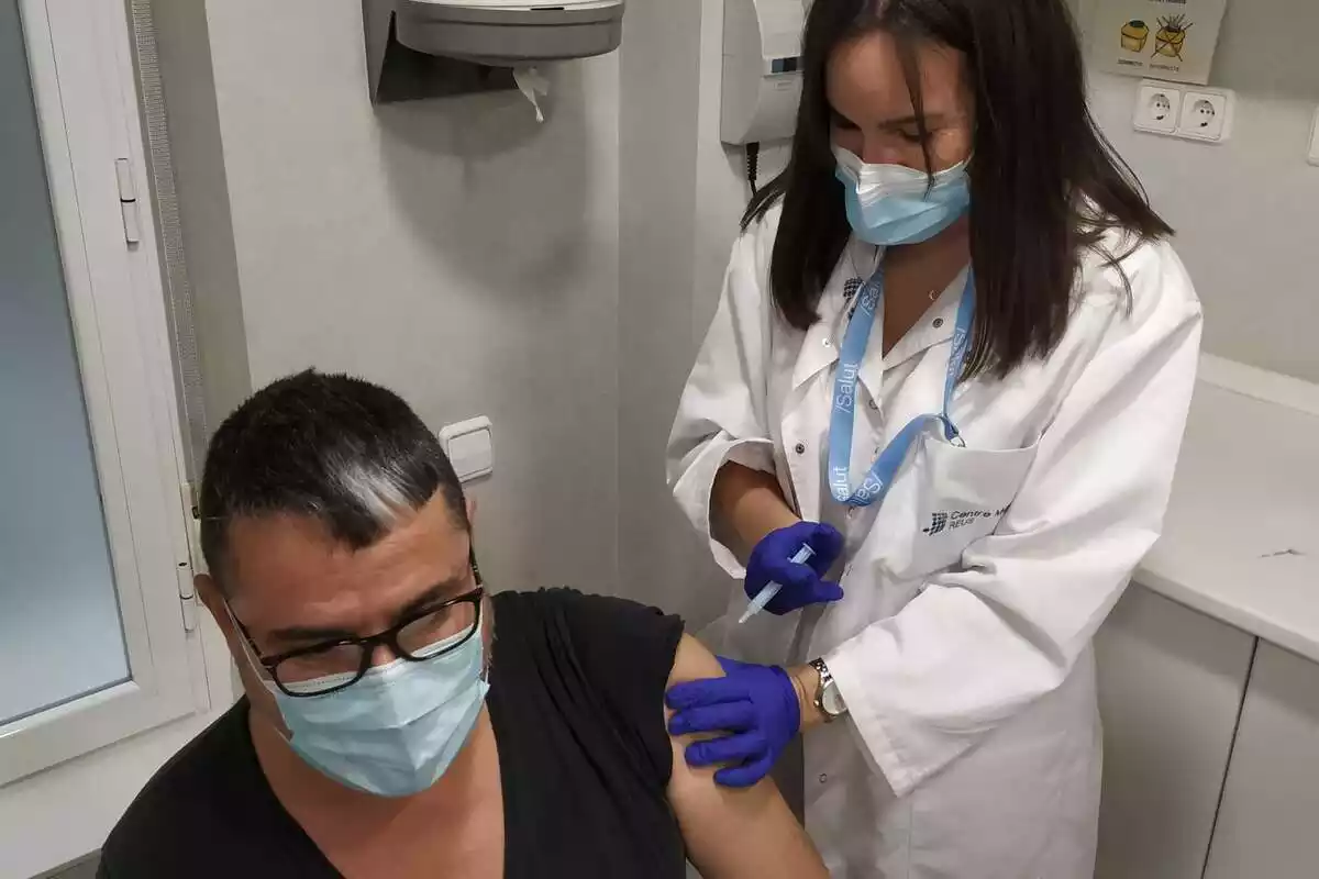 Un home rep una injecció per part d'una infermera