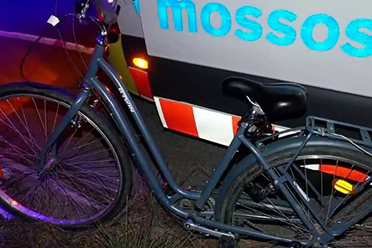 Bicicleta amb un vehicle dels Mossos d'Esquadra.