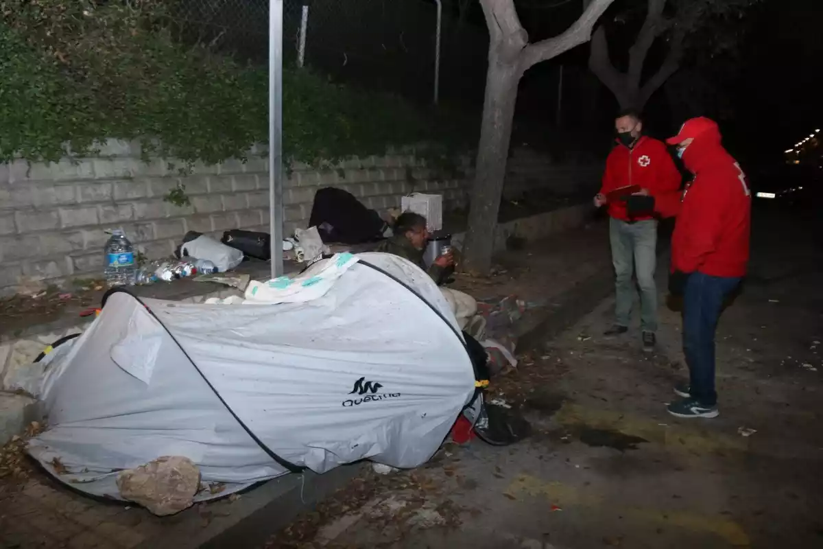 Pla obert de dos voluntaris de Creu Roja atenent un sensesostre durant l'Operació Iglú de Tarragona