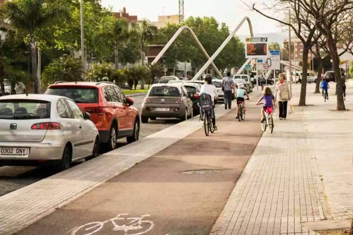 Imatge del carril bici de l'avinguda de Salou de Reus, habilitat sobre la vorera ampla, amb els cotxes aparcats al costat