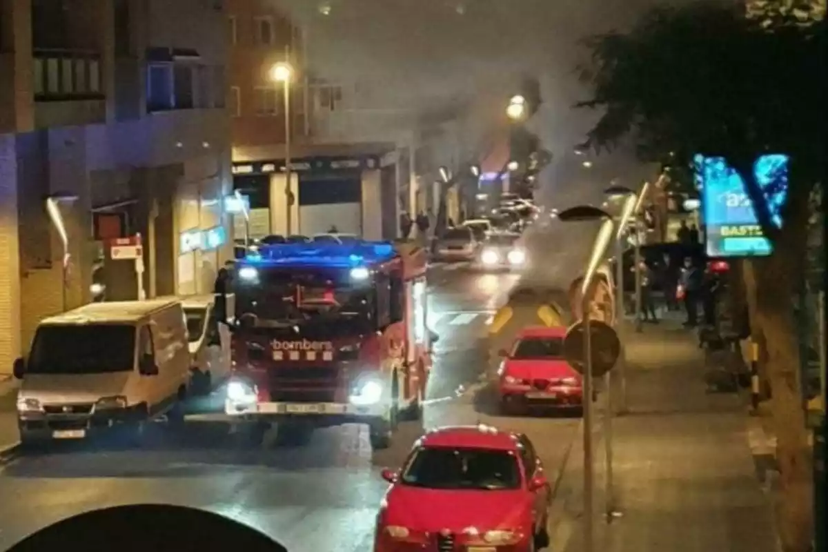 Imatge d'un camió de Bombers al carrer Francesc Bastos de Tarragona amb els contenidors cremant