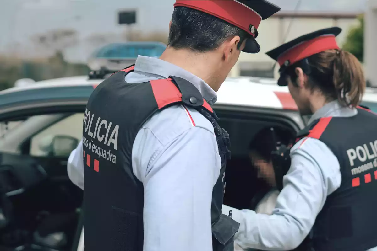 Dos agents dels Mossos d'Esquadra en la detenció d'una persona