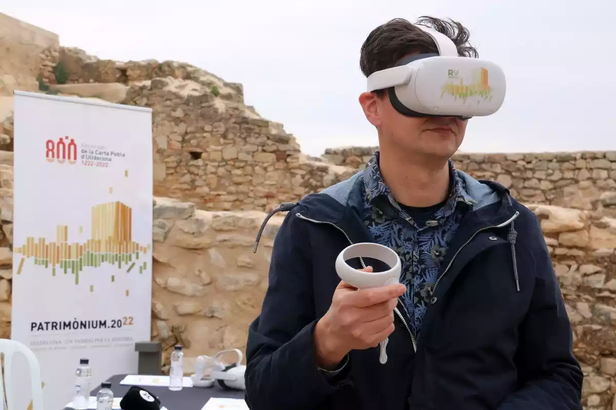 Un tècnic de Cineproad experimentant amb les ulleres de realitat virtual i el comandament al pati d'armes del castell d'Ulldecona