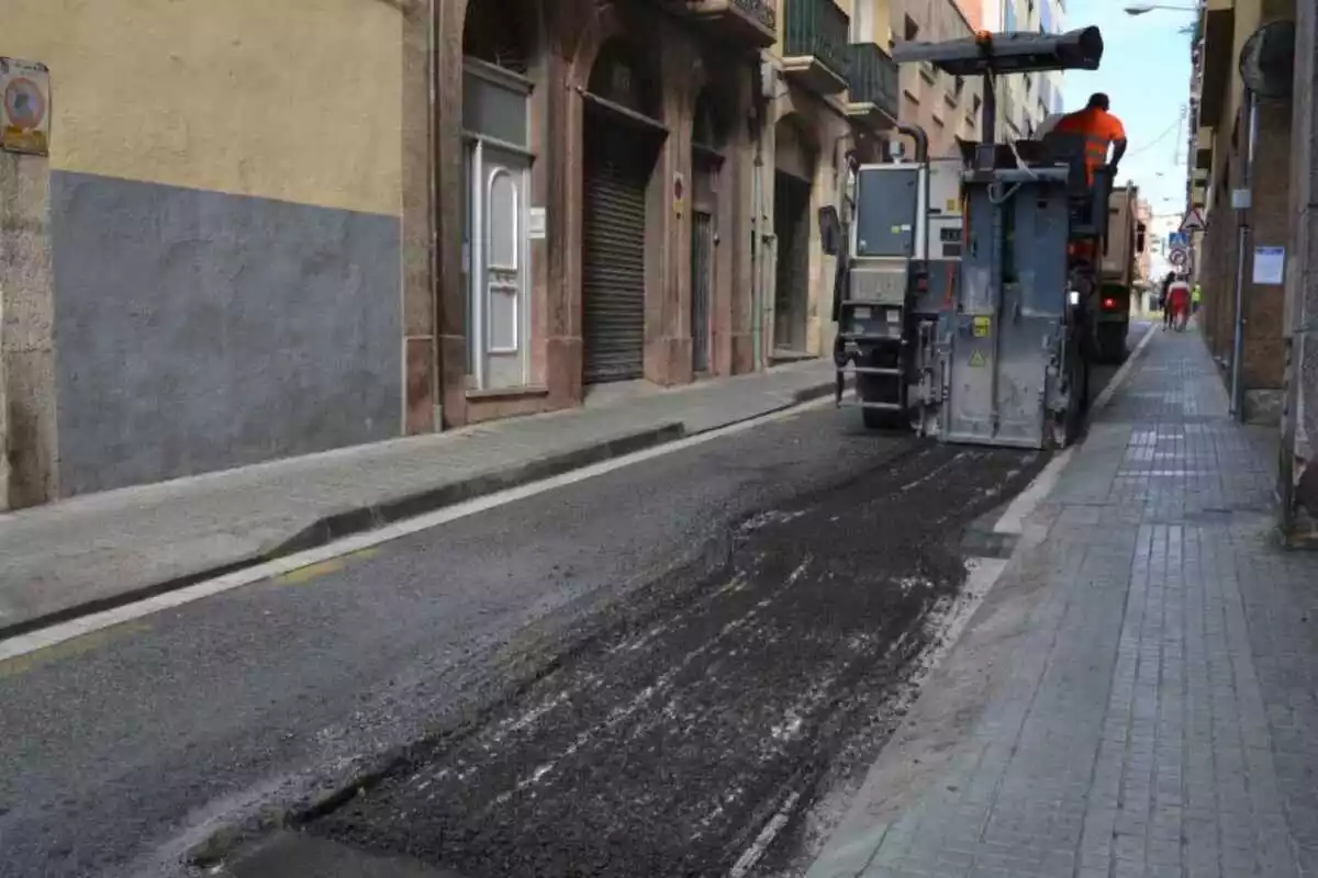 Una màquina d'obra asfalta un carrer de Reus