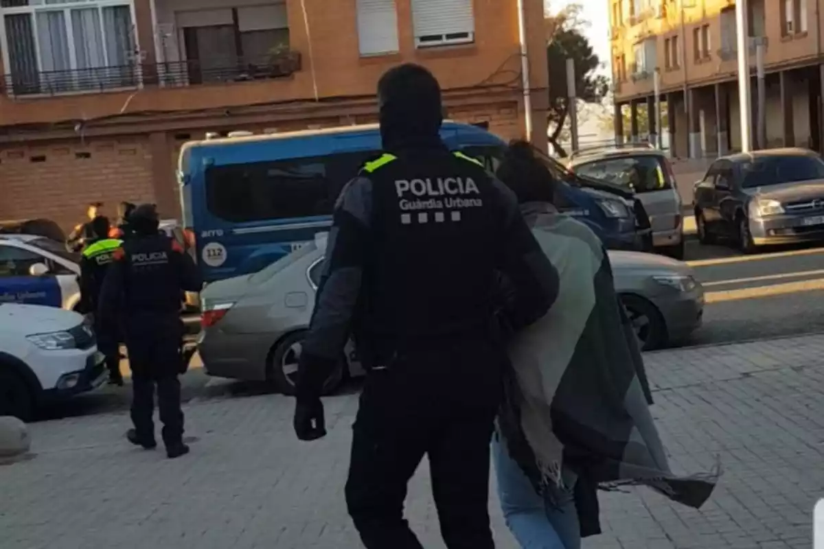 Un agent de la Guàrdia Urbana de Tarragona amb una de les detingudes durant l'operatiu