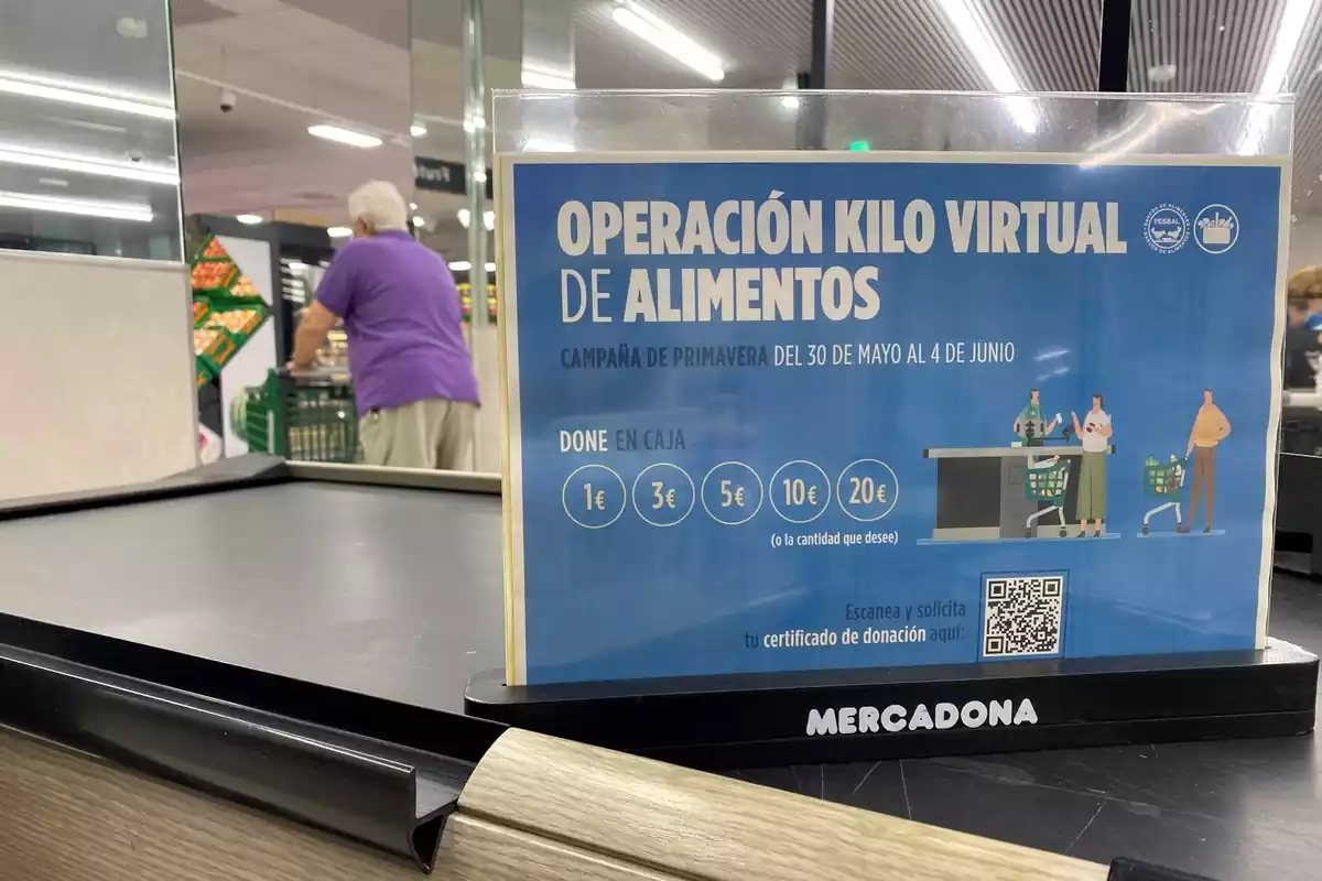 Imatge d'una caixa d'un supermercat Mercadona amb un cartell anunciador de la campanya Operació Quilo