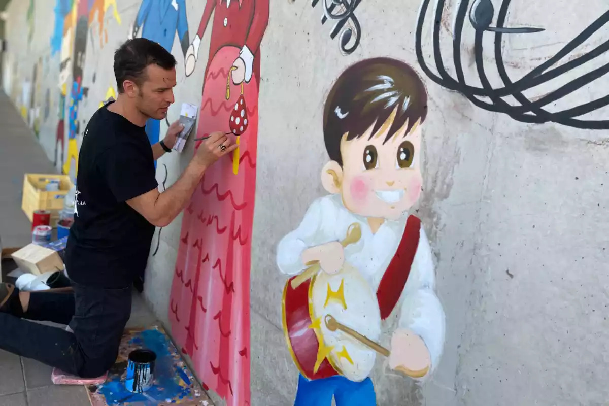 Toni Gallego de Ledaunaire pintant un mural a la Llar d'Infants del Morell