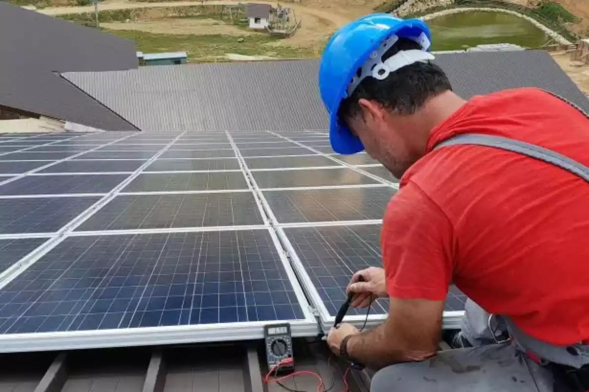 Un tècnic instal·lant unes plaques solars