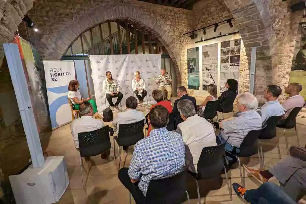 Els tres ponents i la conductora al Castell del Cambrer de Reus, davant del públic present al debat