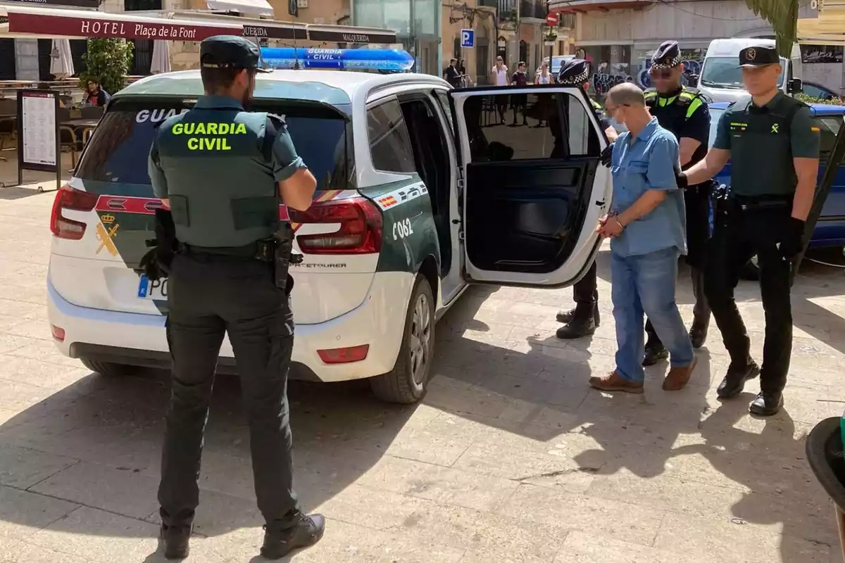 Imatge d'agents de la Guàrdia Civil i la Guàrdia Urbana introduint el detingut a un vehicle de la Benemèrita
