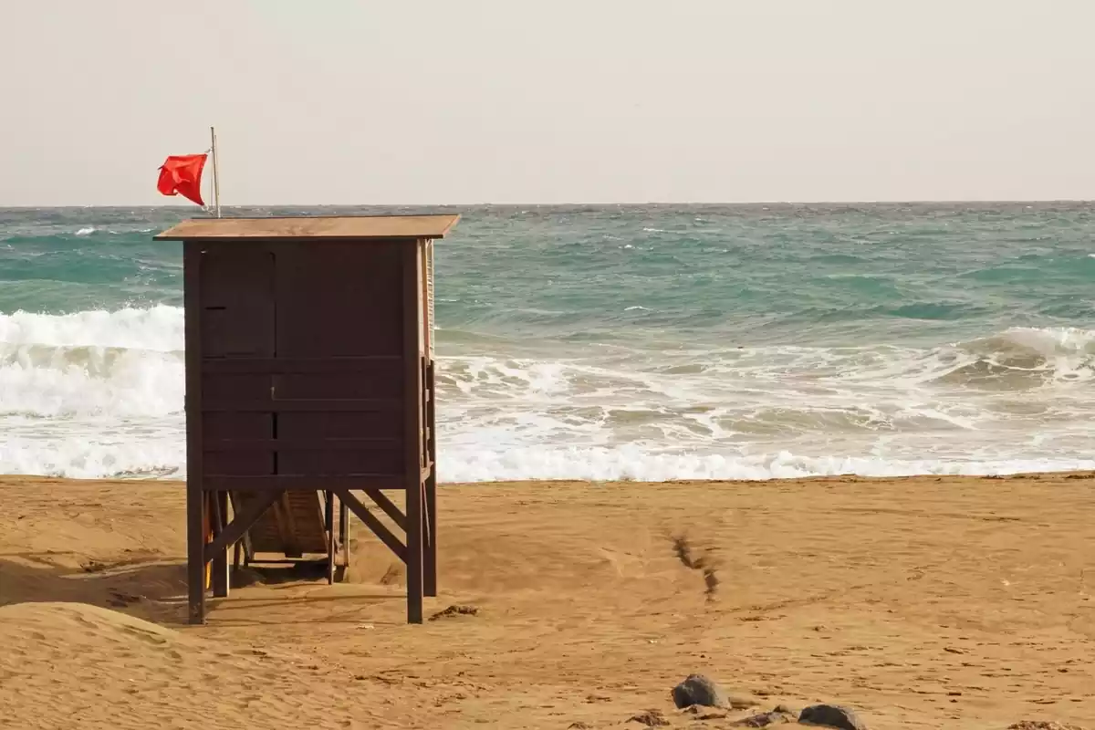 Imatge d'una platja amb bandera vermella