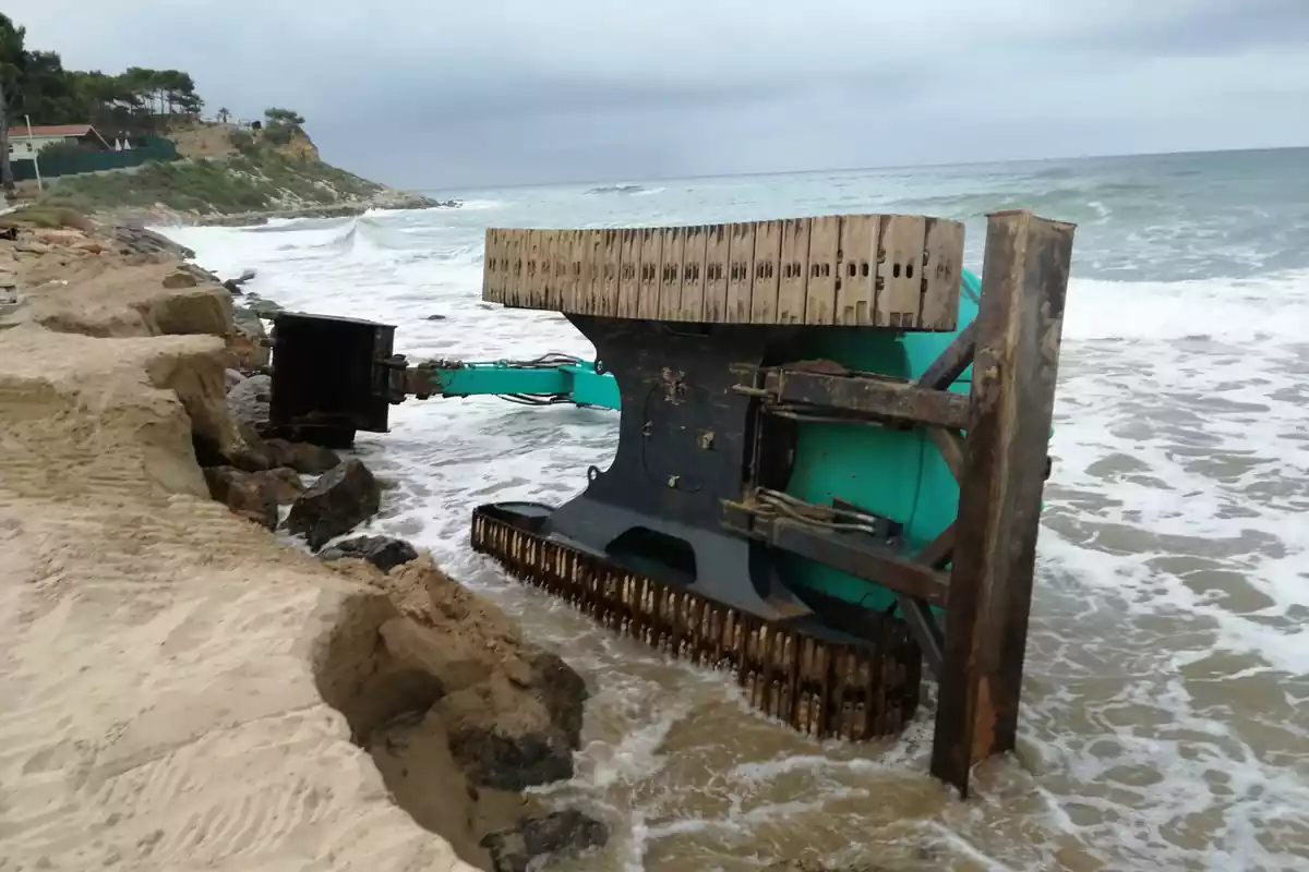 Una màquina bolcada enmig d'una platja de Roda de Berà