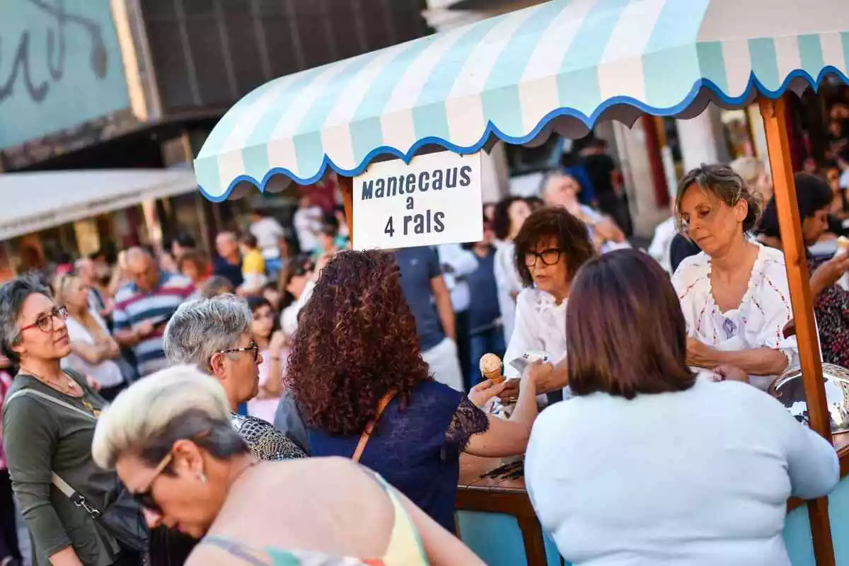Una parada del Mercat a l'Antiga a la plaça del Mercadal de Reus, envoltada de públic visitant