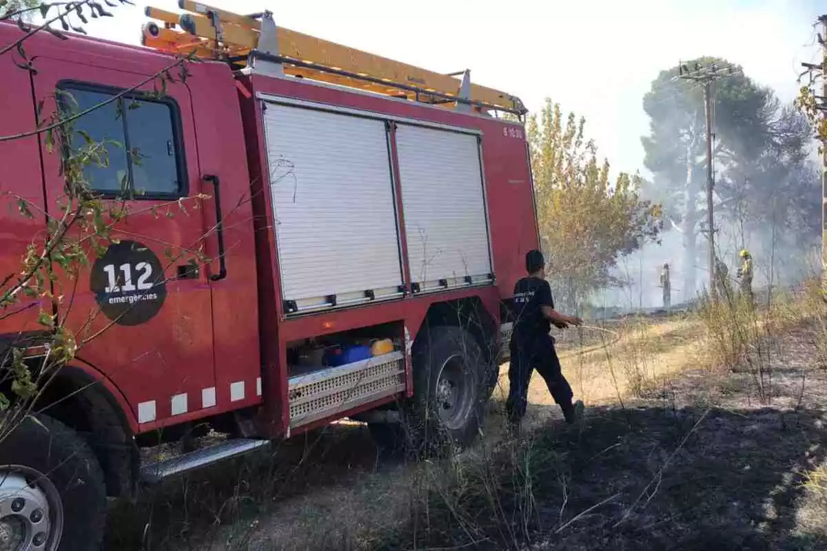 Camió de bombers i bomber en un incendi