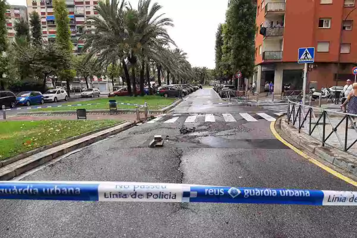 Un tram de l'avinguda del Mediterrani de Reus acordonat amb cinta de la Guàrdia Urbana per un petit esvoranc a l'asfalt