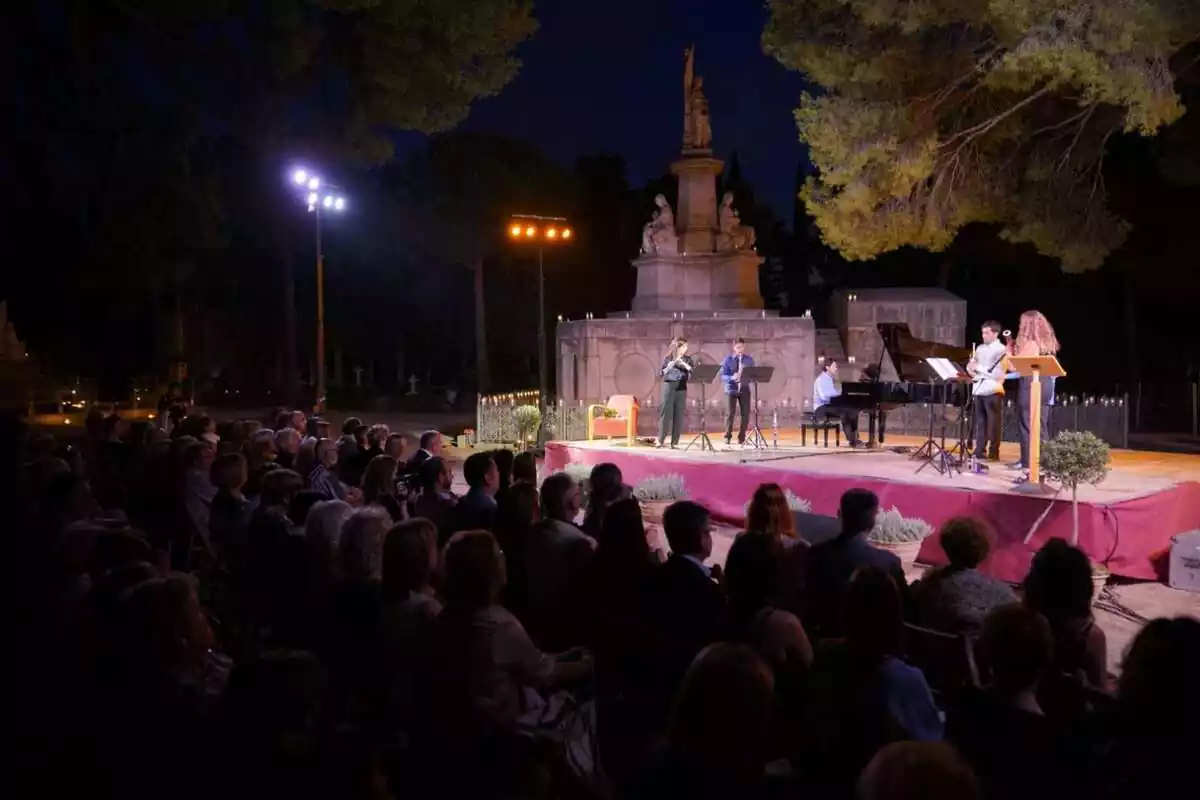 Un conjunt musical tocant, de nit, davant del públic aplegat al Cementiri General de Reus