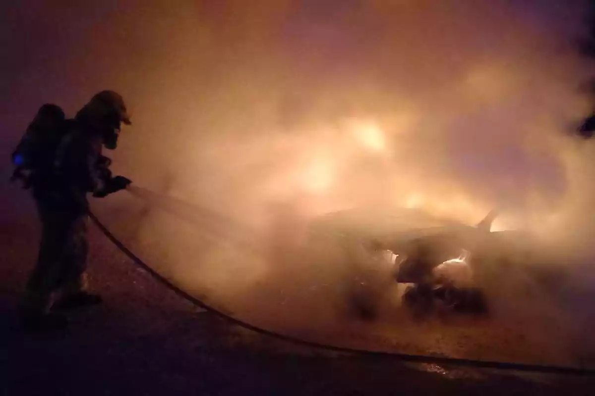 Un bomber apaga les flames d'un vehicle