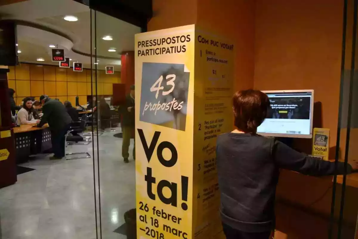 Una persona votant en un ordinador durant la primera edició dels pressupostos participatius de Reus