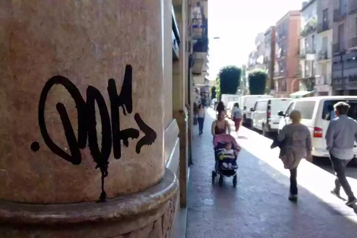 Grafiti pintat en una columna entre el carrer de Jesús i el raval a Reus
