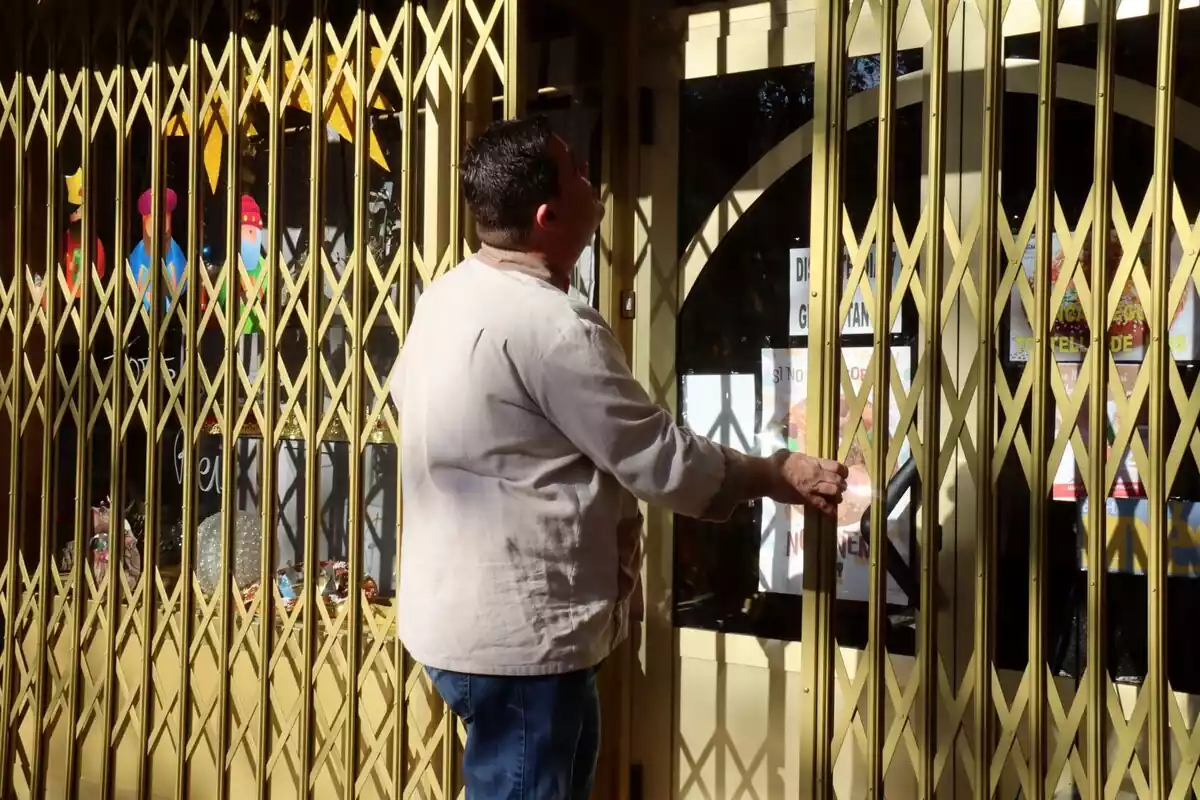El president del Gremi de Forners de Reus i el Baix Camp, Ramón de la Fuente, tancant la porta del seu negoci durant l'aturada reivindicativa
