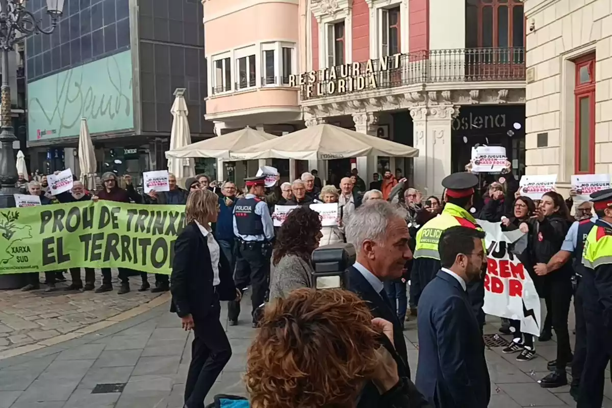 Imatge de Pere Aragonès entrant a l'Ajuntament de Reus amb diversos manifestants al voltant