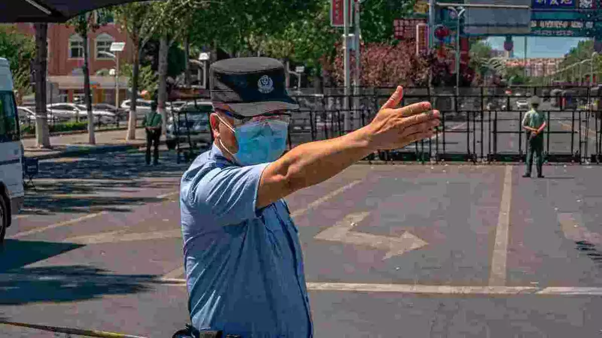 Un policia xinès fa indicacions, assenyalant amb la mà