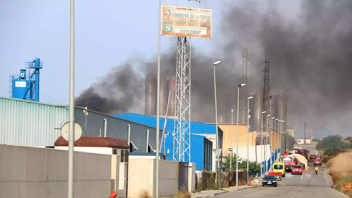 Els efectius d'emergències treballant per apagar el foc en la nau industrial al polígon Entrevies de Tarragona