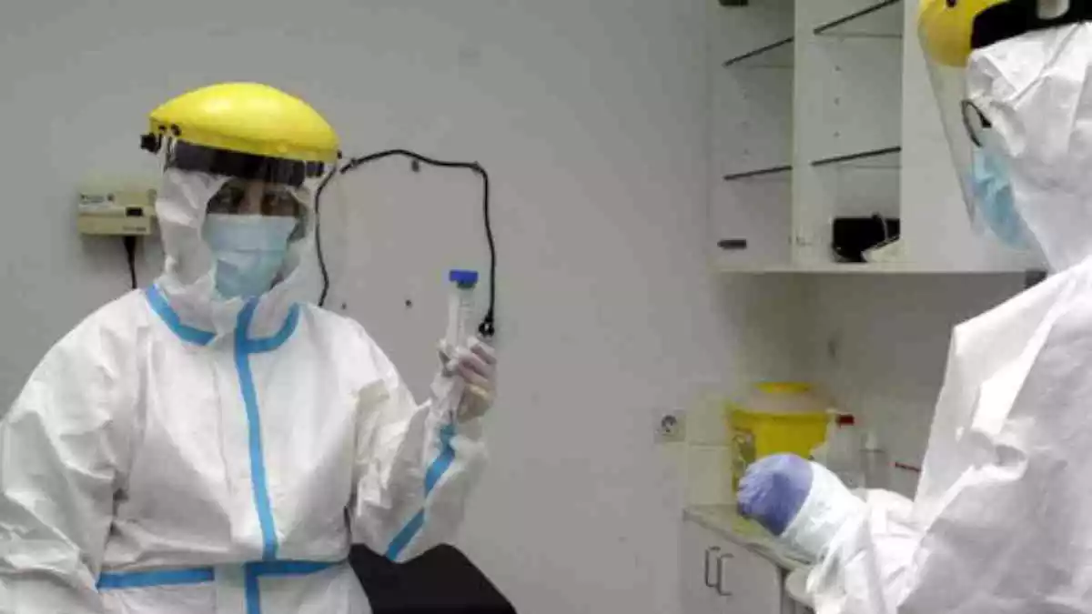 Dues persones amb vestimenta especial per al coronavirus en un laboratori