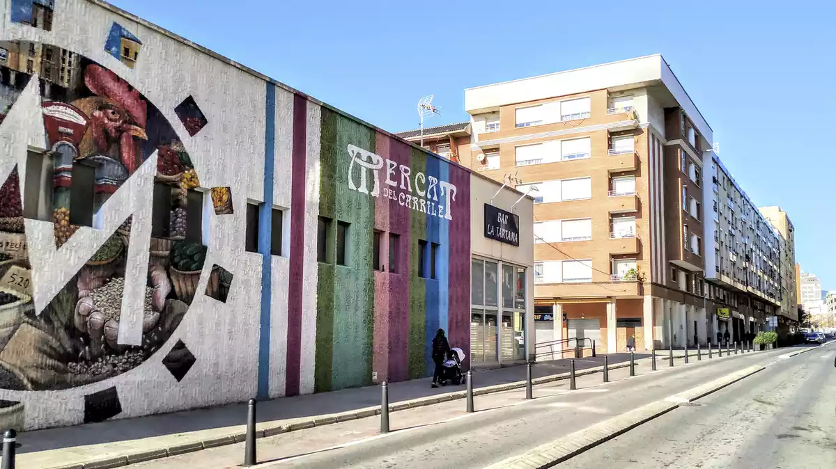 Imatge del carrer de l'escultor Rocamora vist des de la part inferior, amb el Mercat del Carrilet a l'esquerra