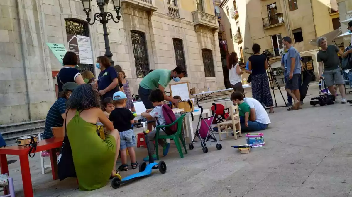 Els pares i mares de les 20 famílies que s'han quedat sense plaça a l'escola pública, a la plaça de la Font amb els seus fills