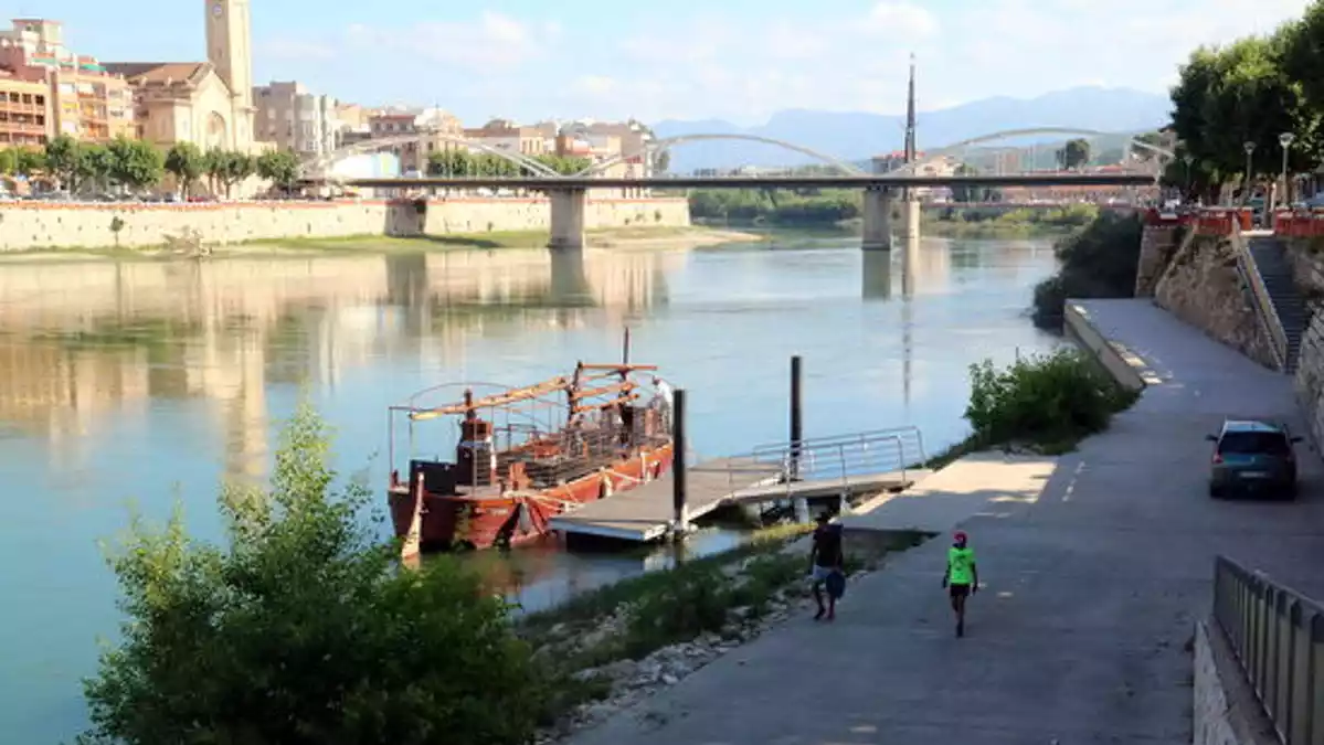 El riu Ebre a Tortosa, amb el llaüt Lo Sirgador de Tortosa amarrat a l'embarcador perquè no reben permisos per tornar a fer viatges turístics