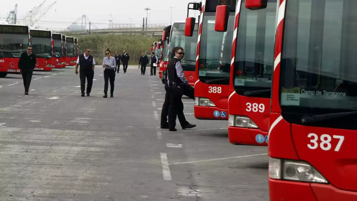 Pla obert de desenes d'autobusos a cotxeres, amb diversos treballadors de l'EMT de Tarragona davant