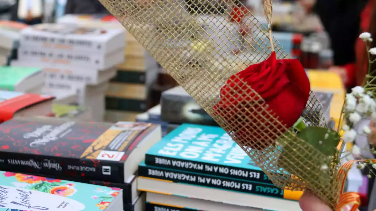 Una parada de llibres de Sant Jordi amb una rosa en primer pla