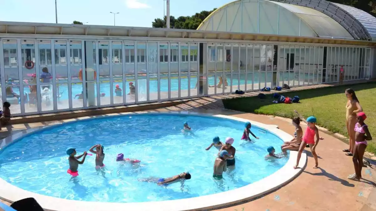 Imatge d'una piscina amb nens jugant-hi