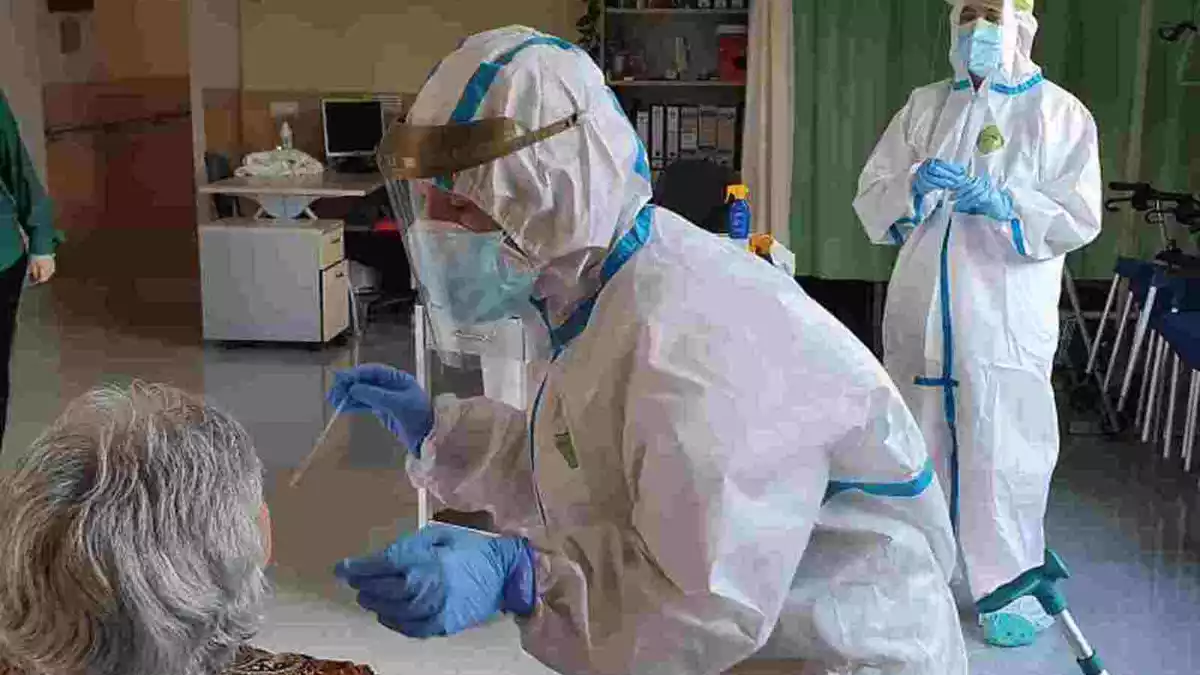 Imatge d'un personal sanitari extraient mostres de PCR en una usuària d'una residència gironina el 25 de maig de 2020