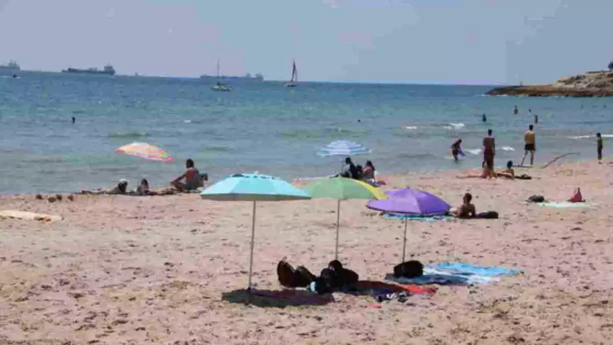 Diverses persones a la platja tarragonina de l'Arrabassada en els primers dies de desescalada