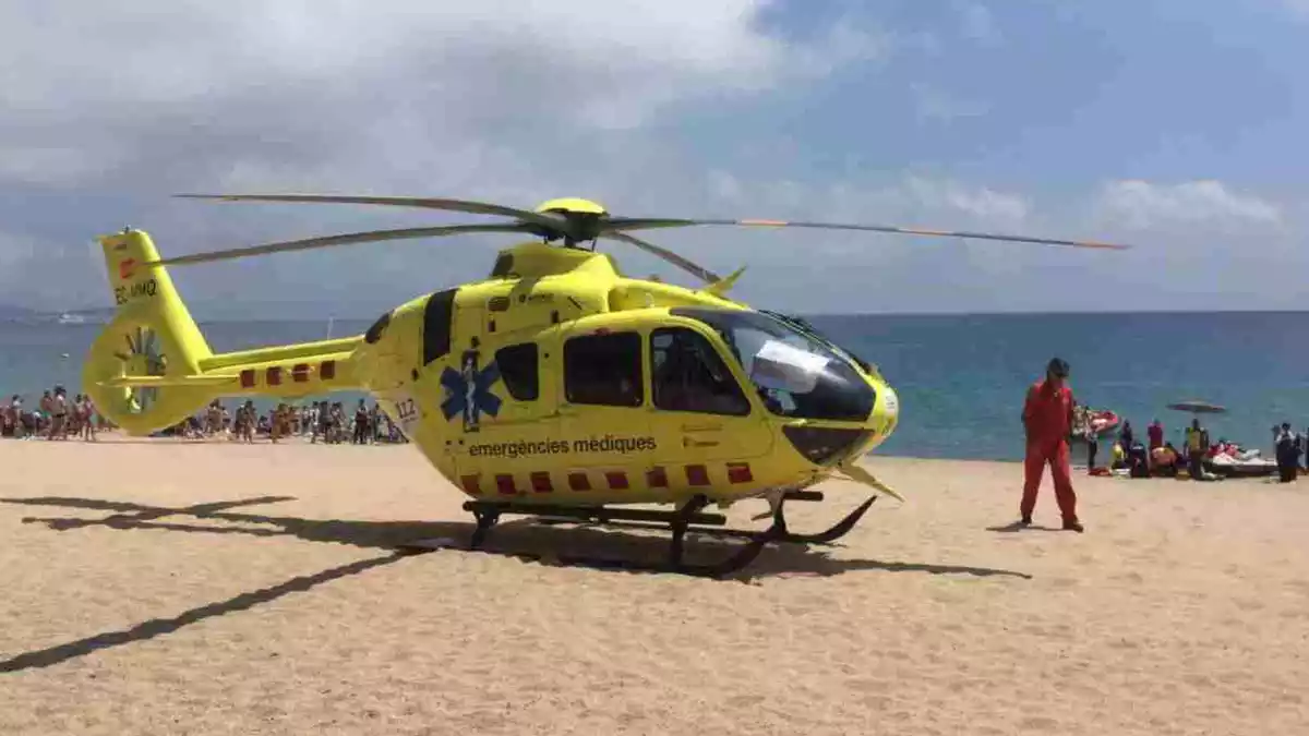 Equips d'emergència practicant maniobres de reanimació a una víctima amb l'helicòpter del SEM en primer terme