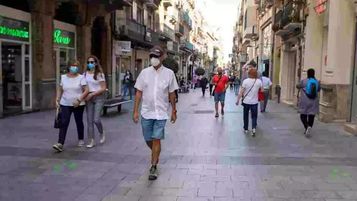 Imatge de diversos ciutadans passejant amb mascareta pel centre de Reus