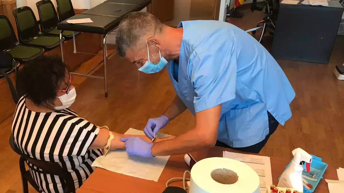 Imatge d'un sanitari fent una prova sanguínia a una dona d'Ascó